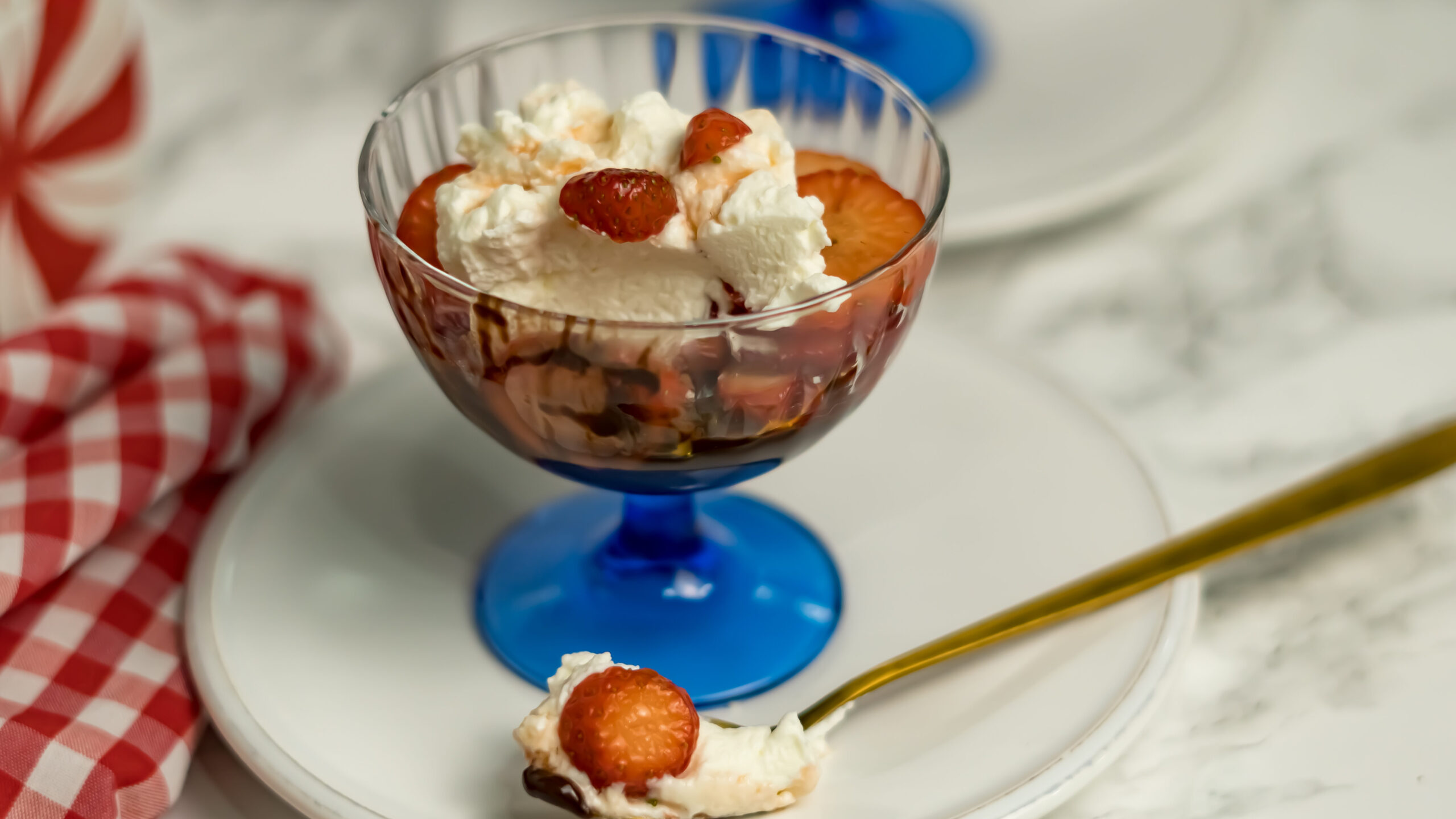 A nice glass with marinated strawberries, sweet whipped cream and warm  dark chocolate